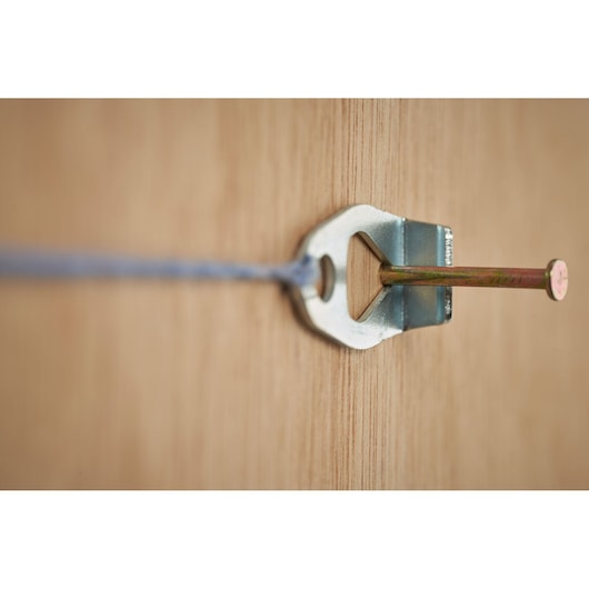 STANLEY STHT47311-0 metal wall hook with nail and string, close-up on wood surface.