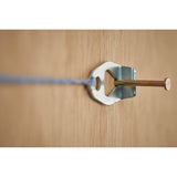 STANLEY STHT47311-0 metal wall hook with nail and string, close-up on wood surface.