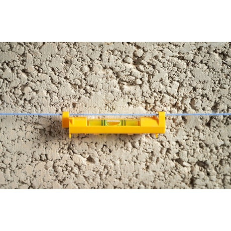 STANLEY STHT47312-0 line level, yellow plastic, shown clipped to a blue string against a textured wall, front angle.