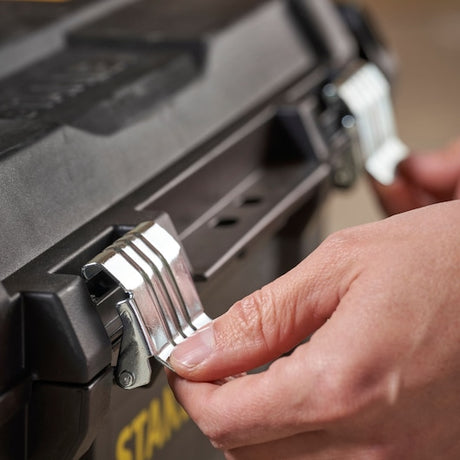 STANLEY STST1-80150 toolbox latch close-up, showing metal clasps and hand opening, product photography.