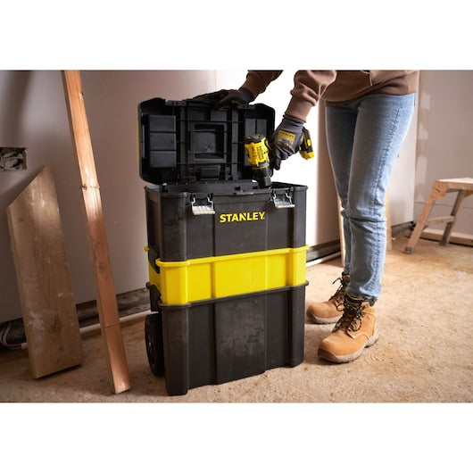 STANLEY STST1-80151 black and yellow rolling tool chest open in workshop, person accessing tools.