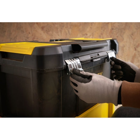 STANLEY STST1-80151 toolbox with yellow lid and metal latches being opened by gloved hands, side angle.