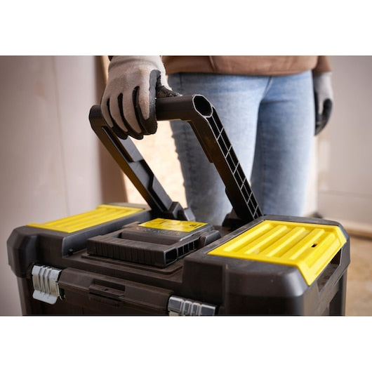STANLEY STST1-80151 toolbox with yellow accents, close-up of handle being held by a gloved hand.