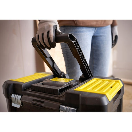 STANLEY STST1-80151 toolbox with yellow accents, close-up of handle being held by a gloved hand.